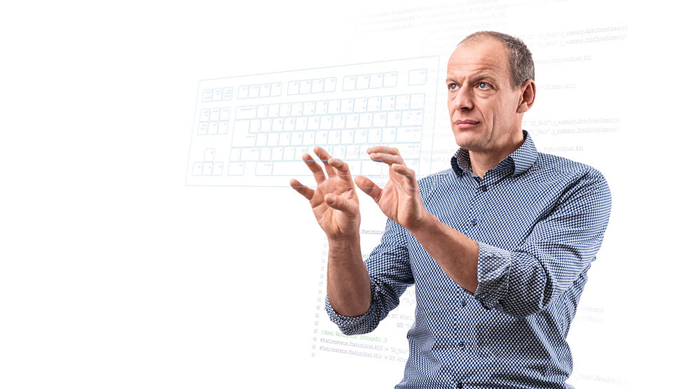 Ein Automatisierungstechniker tippt symbolhaft auf einer virtuellen Tastatur.