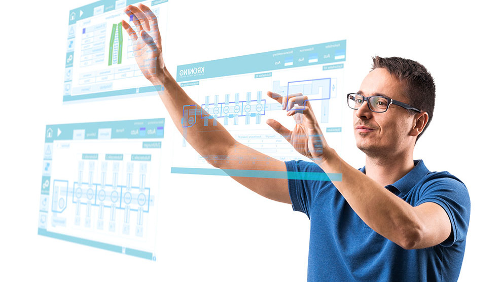 Ein Automatisierungstechniker vergrößert mit seinen Händen symbolhaft einen Automatisierungsplan.